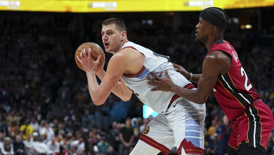 Denver Nuggets center Nikola Jokic, left, is defended by Miami Heat forward Jimmy Butler, right, during the second half of Game 5 of basketball's NBA Finals, Monday, June 12, 2023, in Denver. (AP Photo/Jack Dempsey)